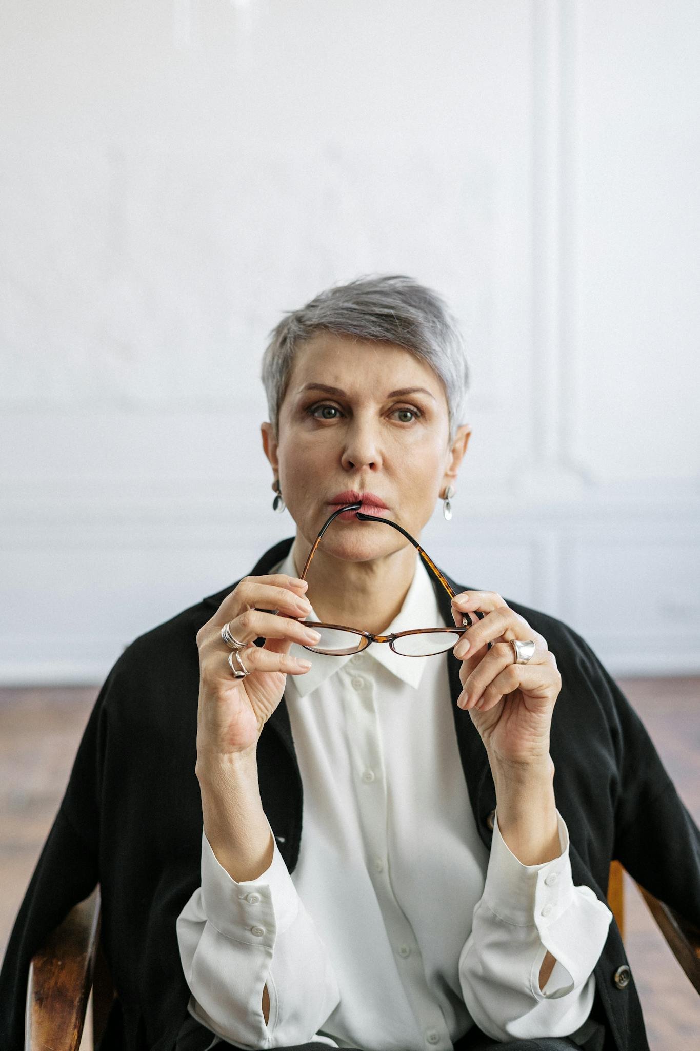 a contemplative senior woman holds her glasses - Services